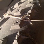 Cocktail stick-size thorns through faty bike tread.