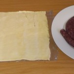Coil of boerewors and sheet of puff pastry.