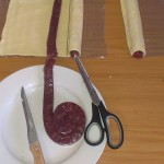 Third length of wors laid out with two lengths rolled up.