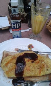 Omelette, toast, juice and HP Sauce for breakfast